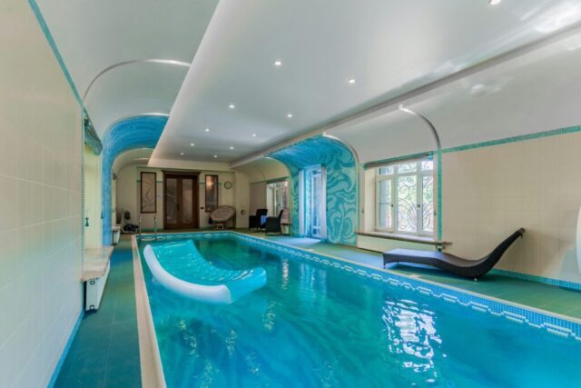 Luxurious indoor swimming pool featuring an inflatable sunbed and elegant design elements.